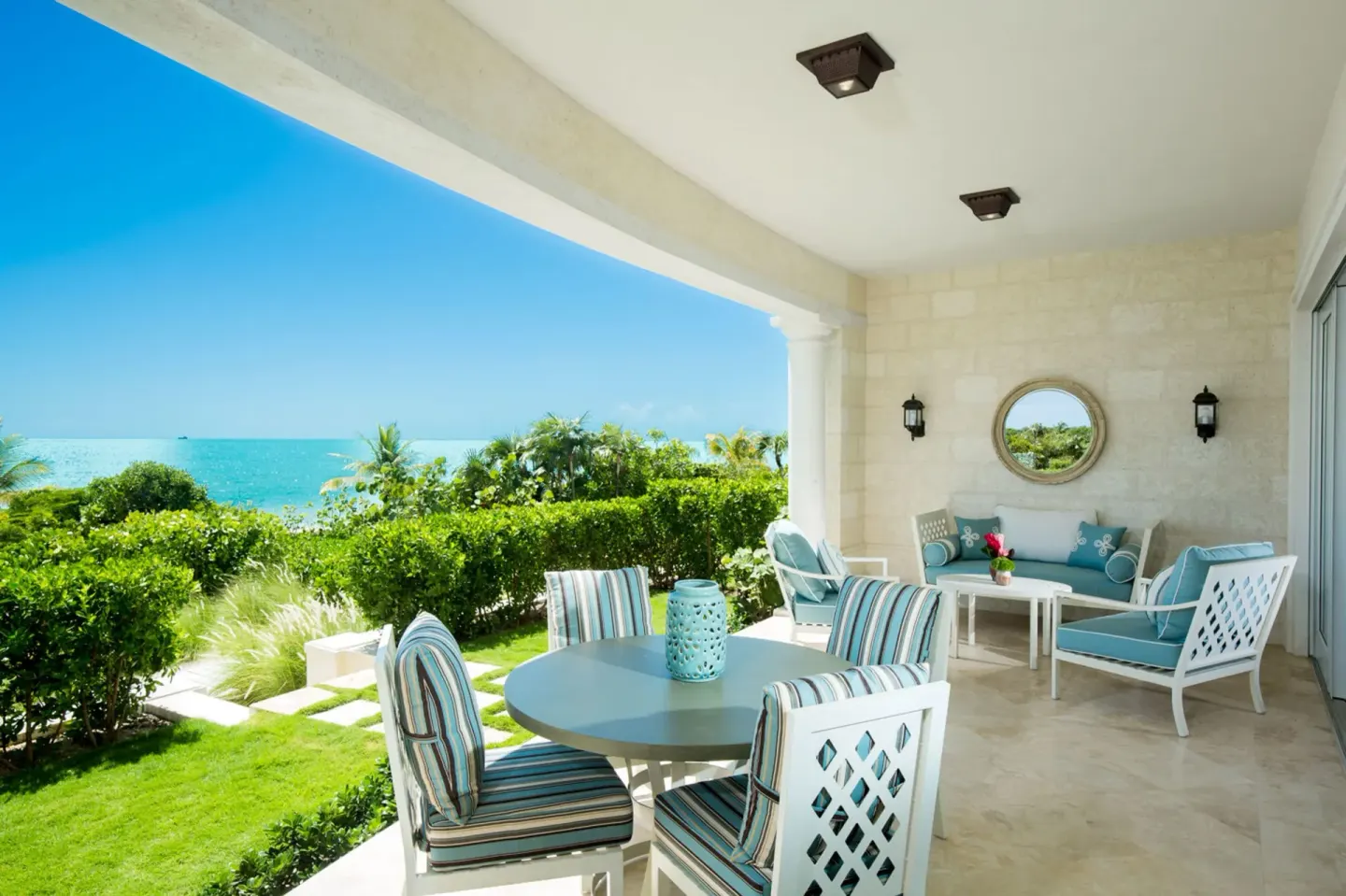 Oceanfront terrace with dining table and lounge seating at The Shore Club Turks and Caicos.
