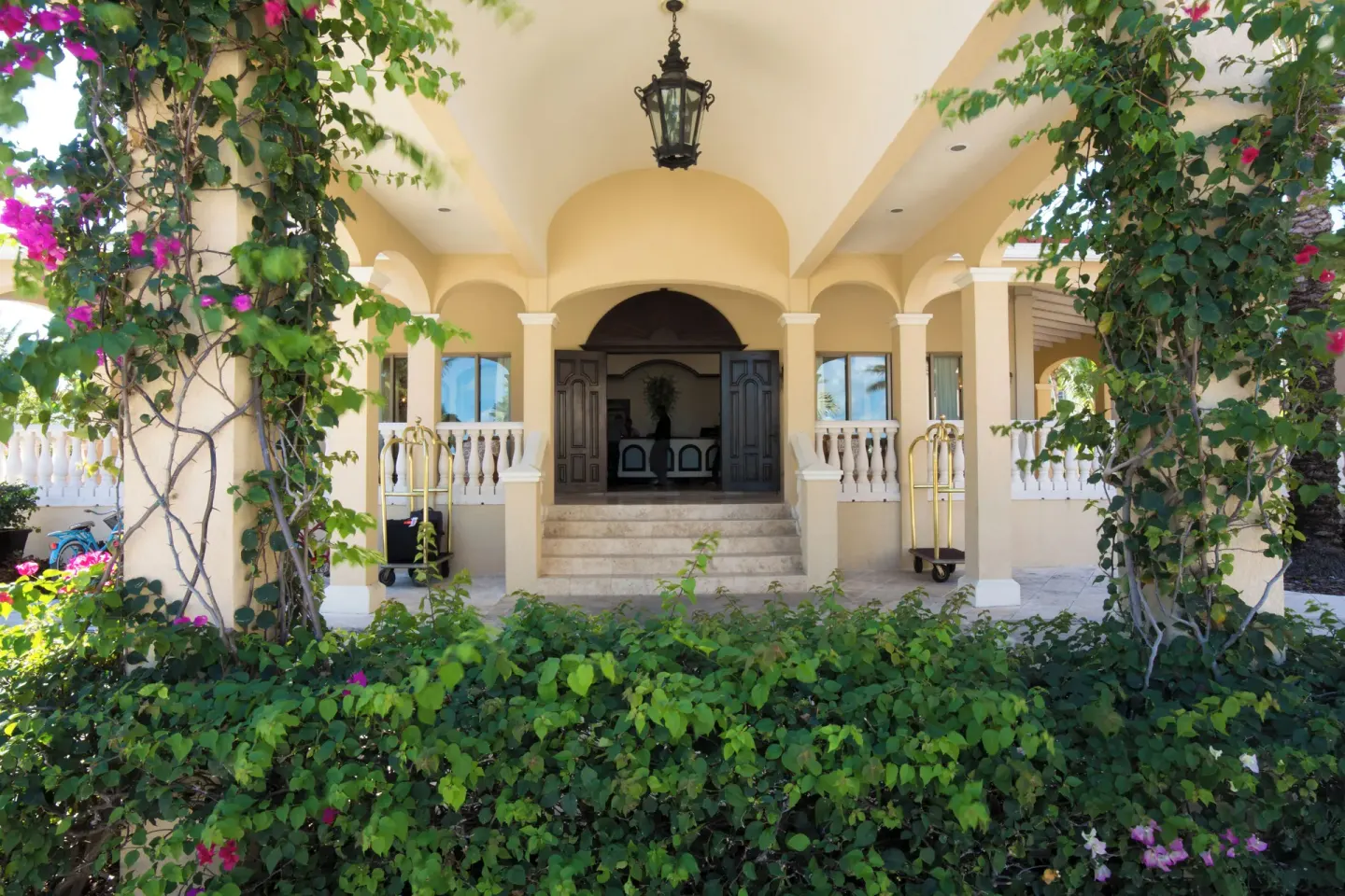 Arched lobby entrance with vines and luggage carts at The Somerset on Grace Bay.