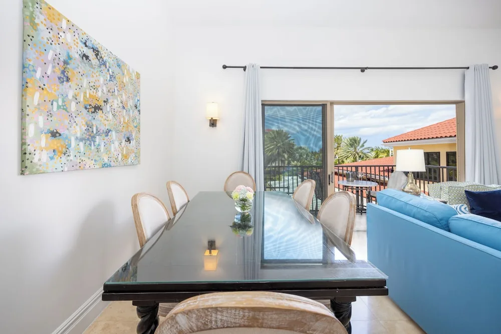 Dining table beside balcony doors in a 1 Bedroom Residence at The Somerset on Grace Bay.