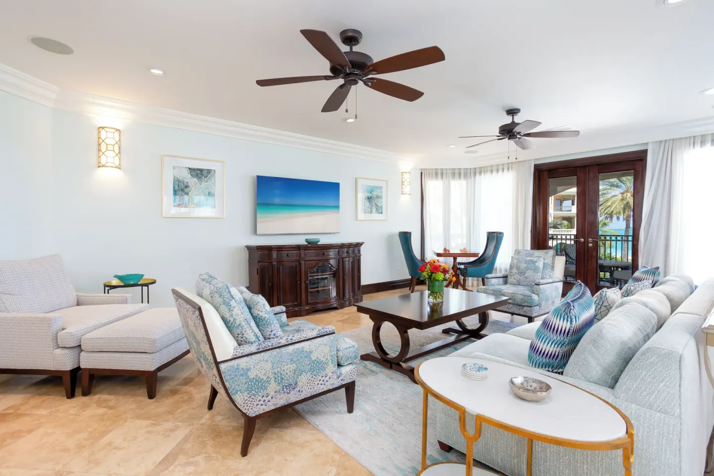 Living room with sofas, lounge chairs, and balcony doors at The Somerset on Grace Bay.