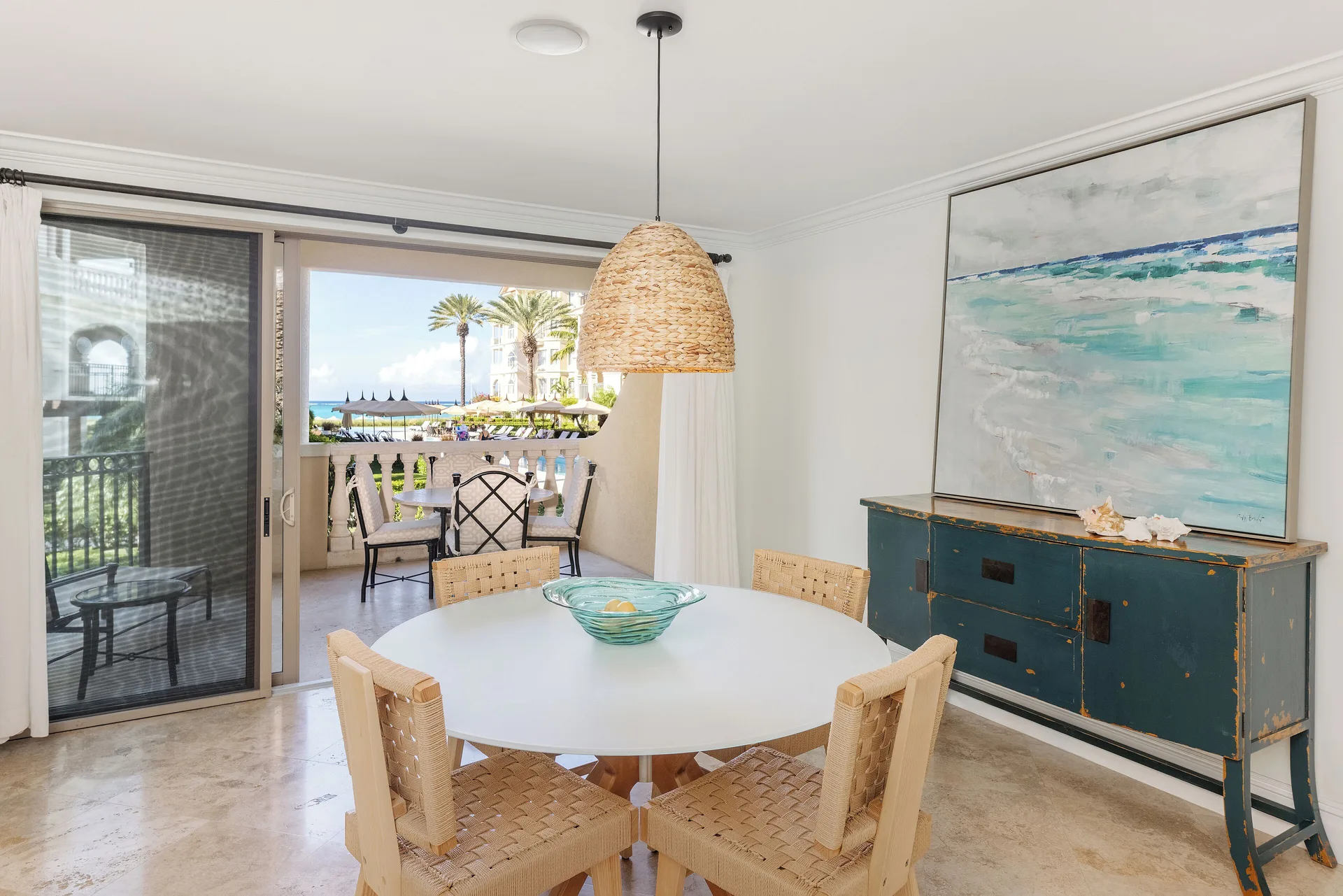 Villa 1 Bedroom Pool View dining table with open balcony doors at The Somerset on Grace Bay.