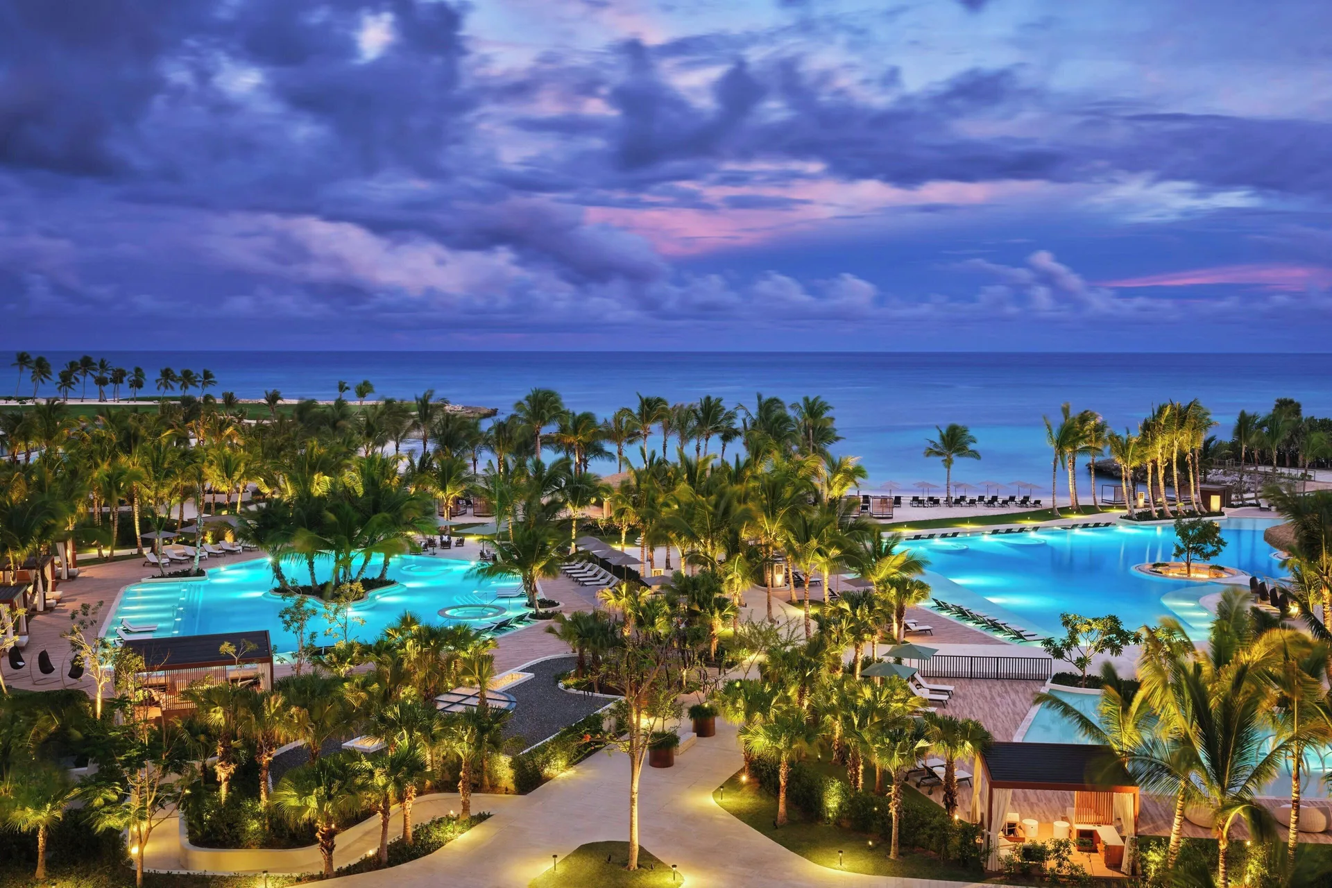 The St. Regis Cap Cana Resort luxury beachfront property in Cap Cana, Dominican Republic with infinity pool and Caribbean Sea views at twilight.