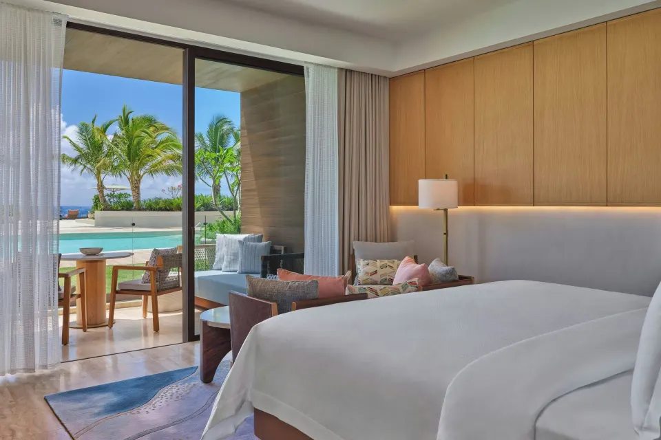 Deluxe Room with king bed and poolside balcony at The St Regis Cap Cana Resort.