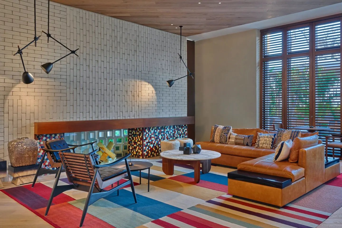 Colorful lounge with leather sofa and patterned rug at The St. Regis Kanai Resort, Riviera Maya.