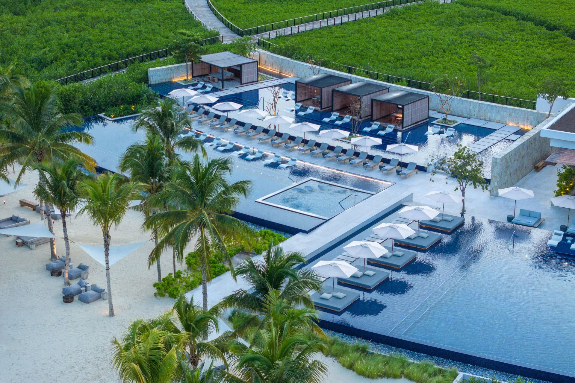 Elevated view of pool decks, cabanas and palms at The St. Regis Kanai Resort, Riviera Maya.