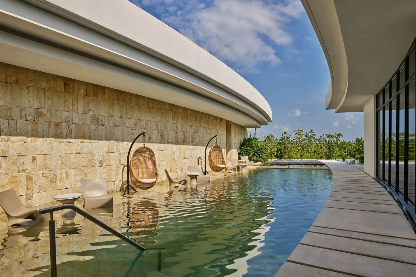 Curved hydrotherapy pool with in-water loungers at The St. Regis Kanai Resort, Riviera Maya.