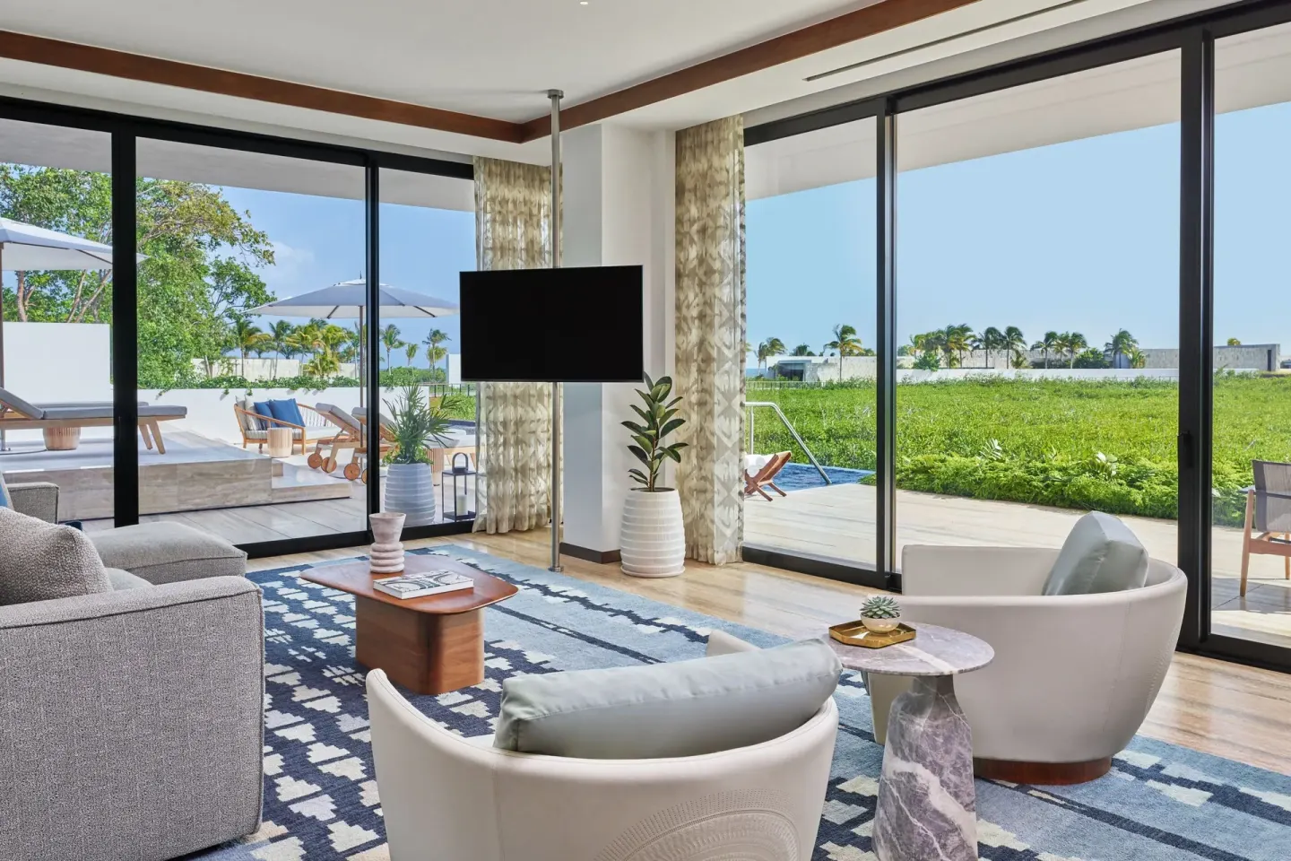 Suite sitting room with terrace doors and greenery at The St. Regis Kanai Resort, Riviera Maya.