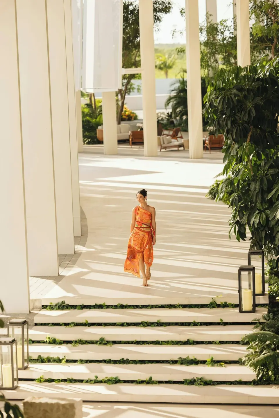 Sunlit colonnade with steps, lanterns, and tropical plants at The St. Regis Kanai Resort, Riviera Maya.