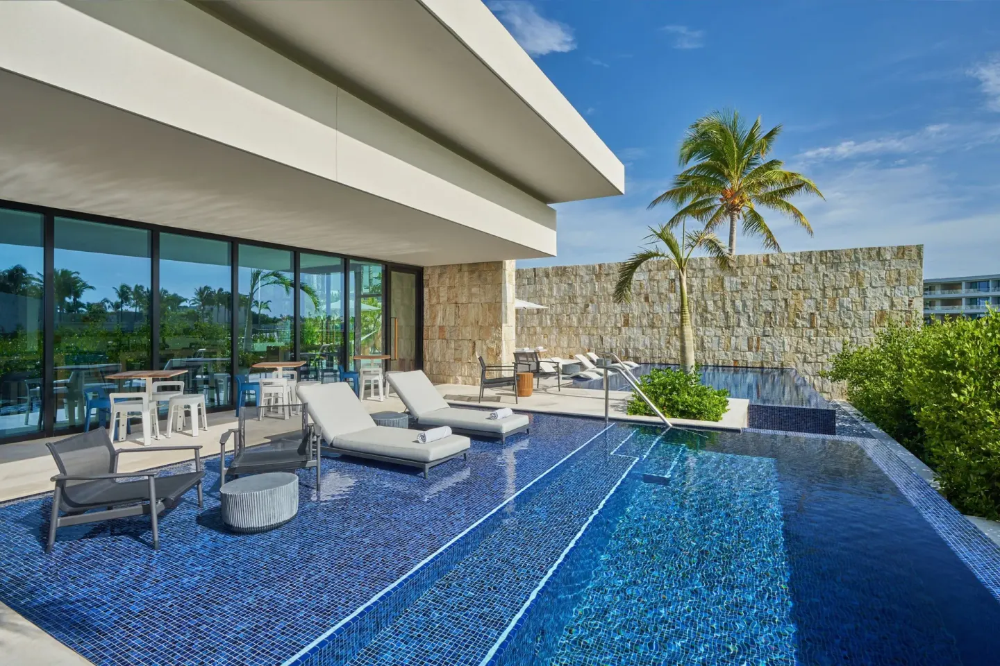 Blue-tiled pool beside a modern terrace at The St. Regis Kanai Resort, Riviera Maya.