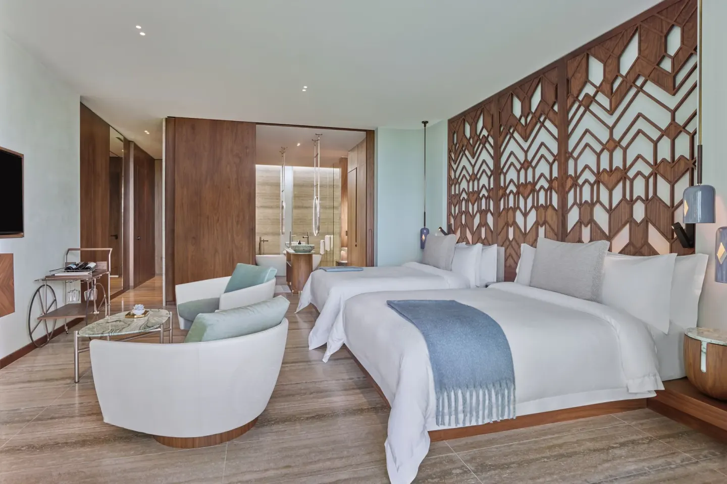 Deluxe Room with two beds and carved wood headboard at The St. Regis Kanai Resort, Riviera Maya.