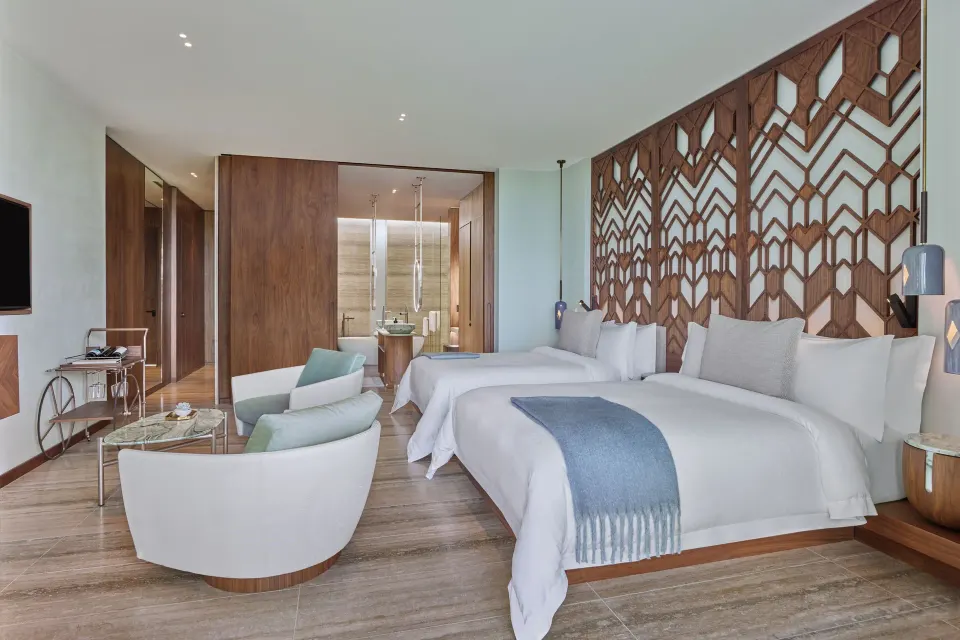 Deluxe Room with two beds and carved wood headboard at The St. Regis Kanai Resort, Riviera Maya.