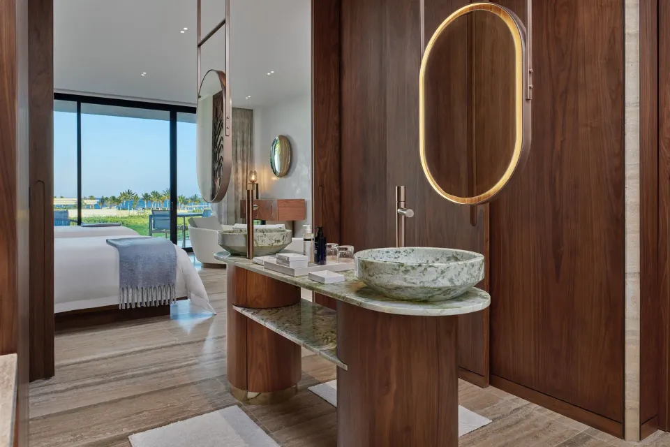 Deluxe Room vanity with round basin and bedroom ocean view at The St. Regis Kanai Resort, Riviera Maya.
