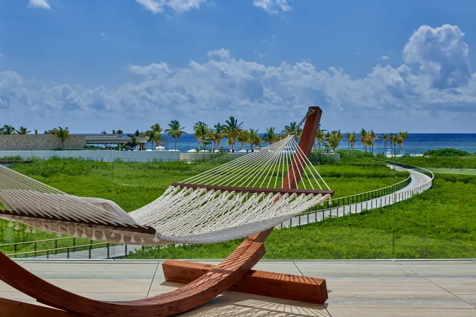 Balcony hammock overlooking palms and the ocean at The St. Regis Kanai Resort, Riviera Maya.
