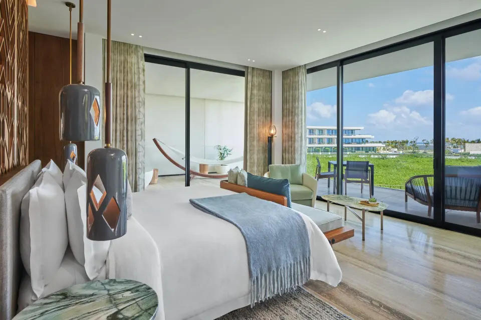 King bed beside floor-to-ceiling windows in an Ocean View room at The St. Regis Kanai Resort, Riviera Maya.