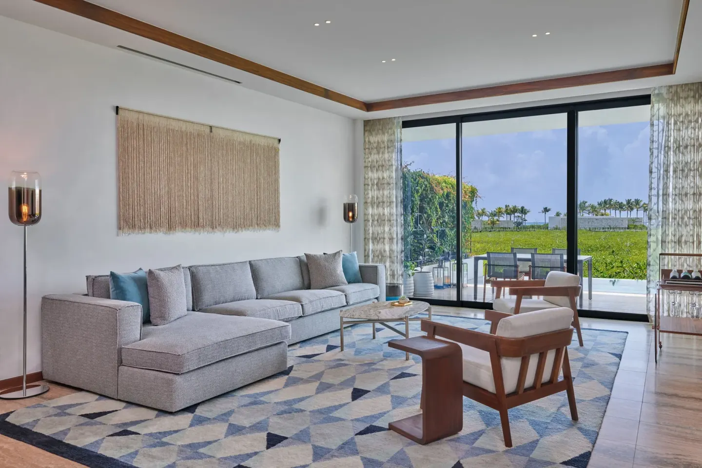 Ocean View Suite living room at The St. Regis Kanai Resort with terrace and greenery beyond.