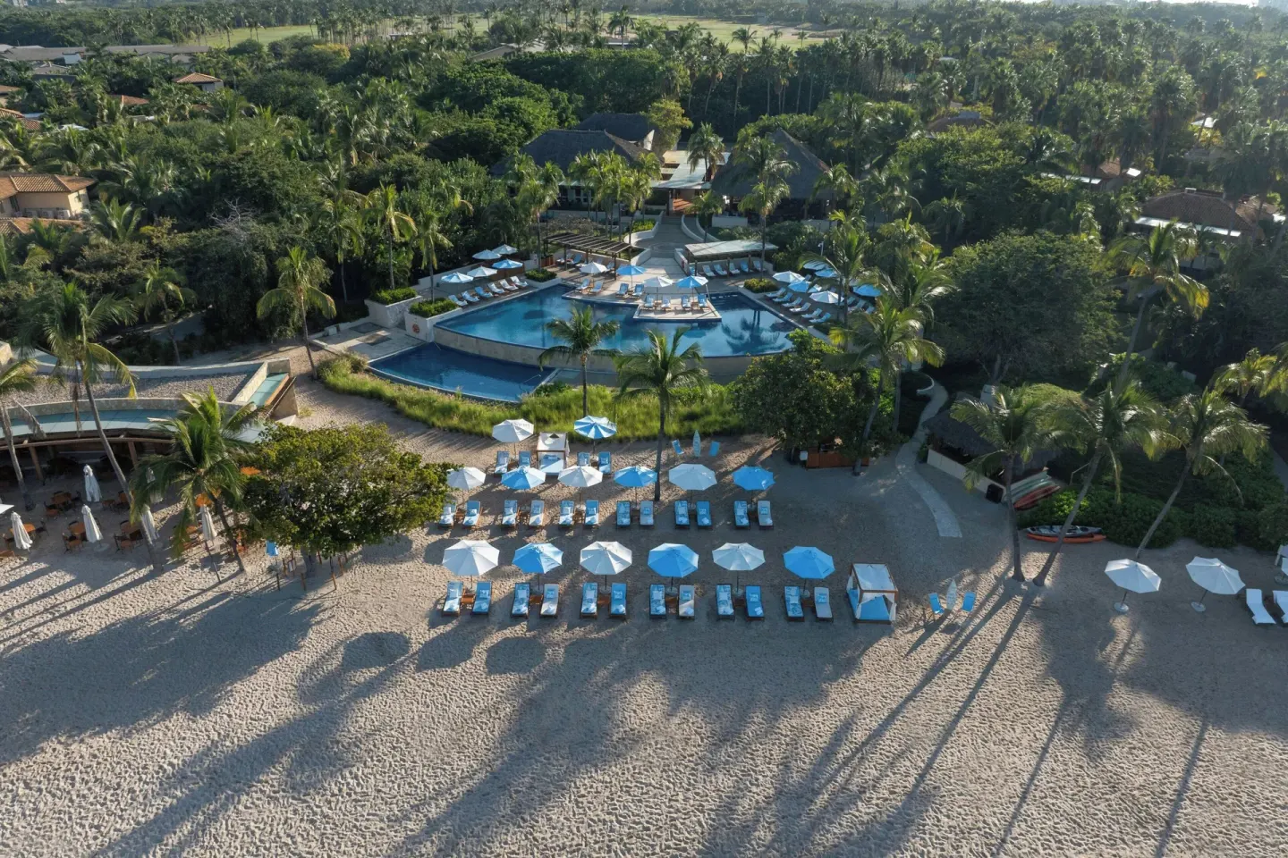Aerial view of the beach, pool, and palm-filled grounds at The St. Regis Punta Mita Resort.