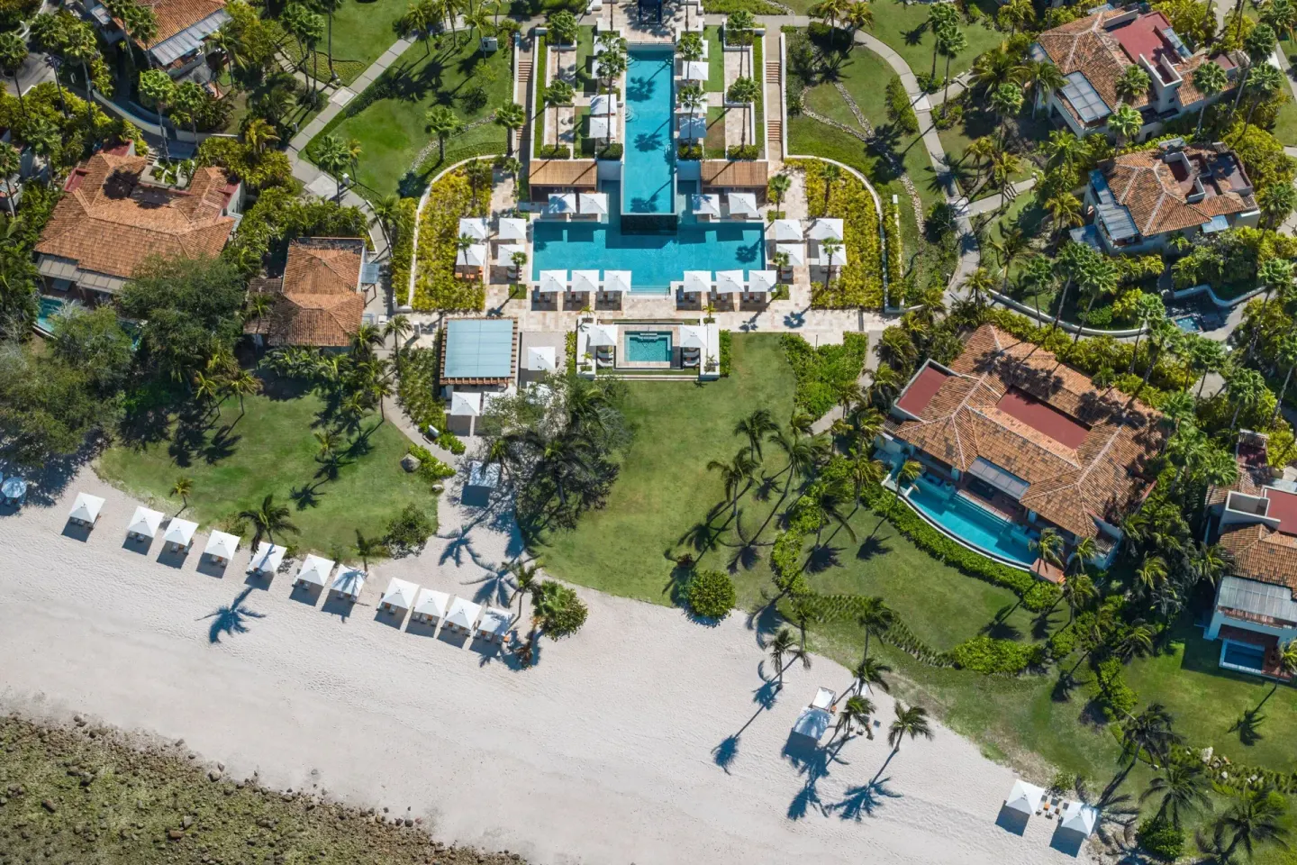 Aerial view of the beach, lawns, and pool at The St. Regis Punta Mita Resort.