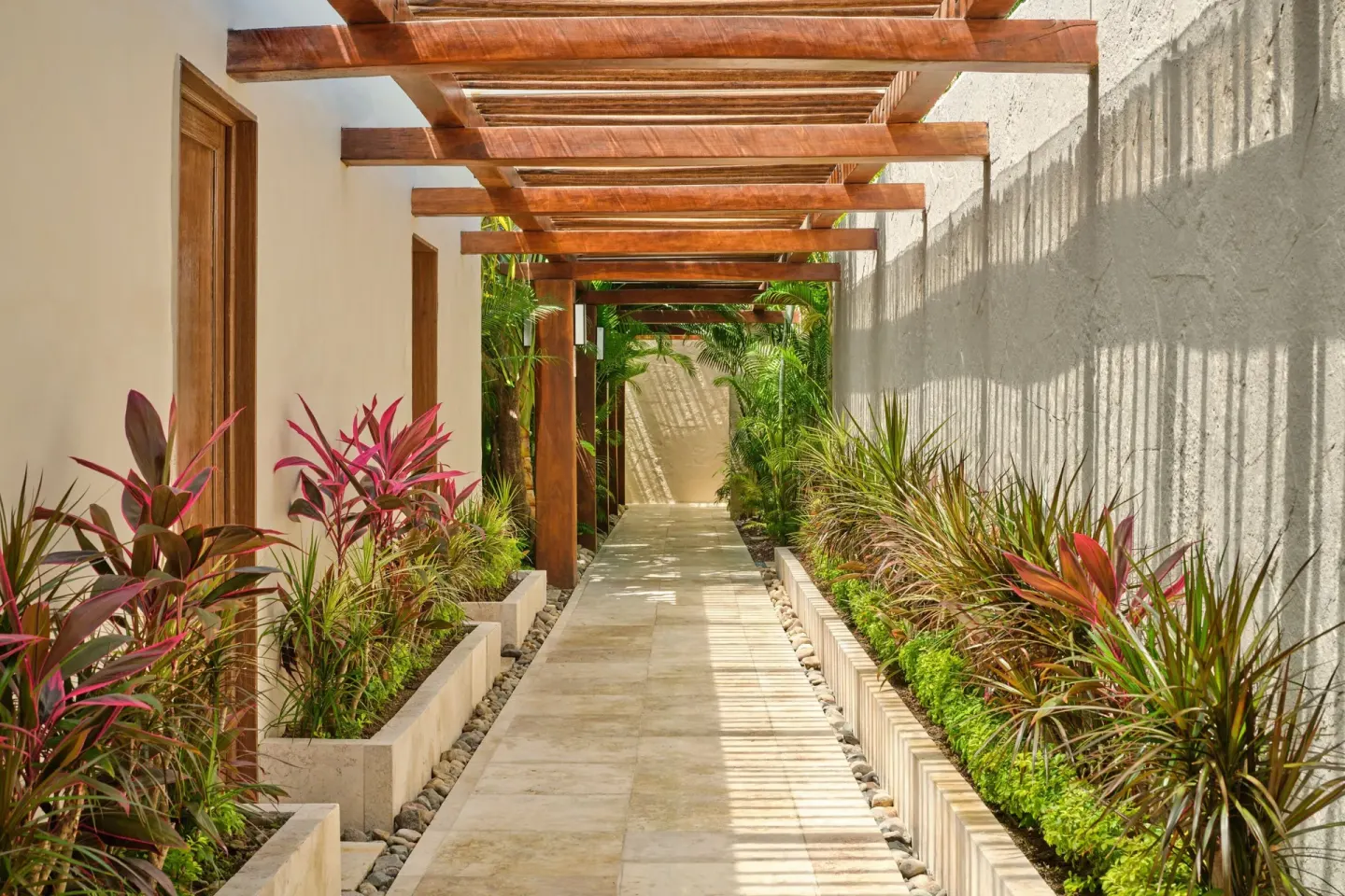 Covered garden walkway with wood beams at The St. Regis Punta Mita Resort.