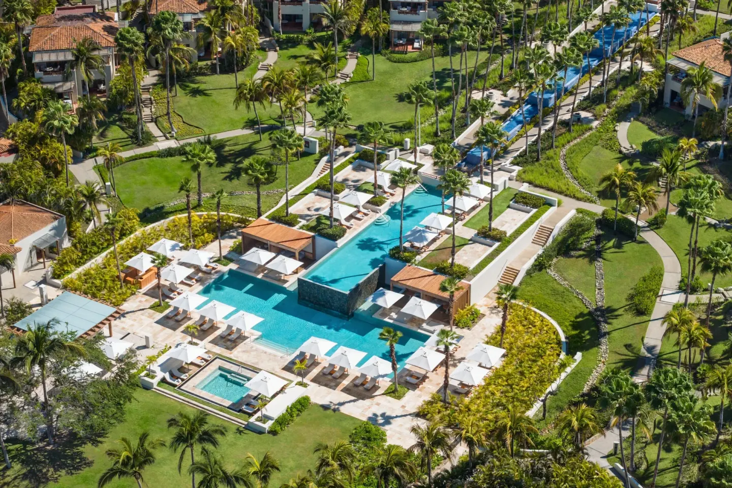 Aerial view of the main pool terrace and palm gardens at The St. Regis Punta Mita Resort.