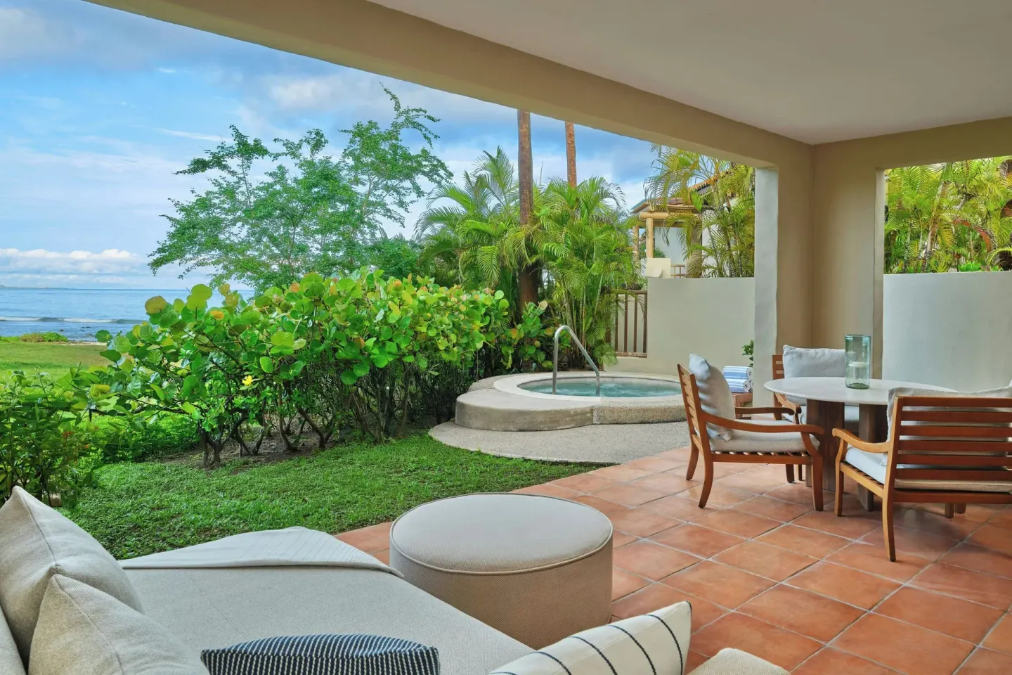 Covered oceanfront terrace with seating and a spa tub at The St. Regis Punta Mita Resort.