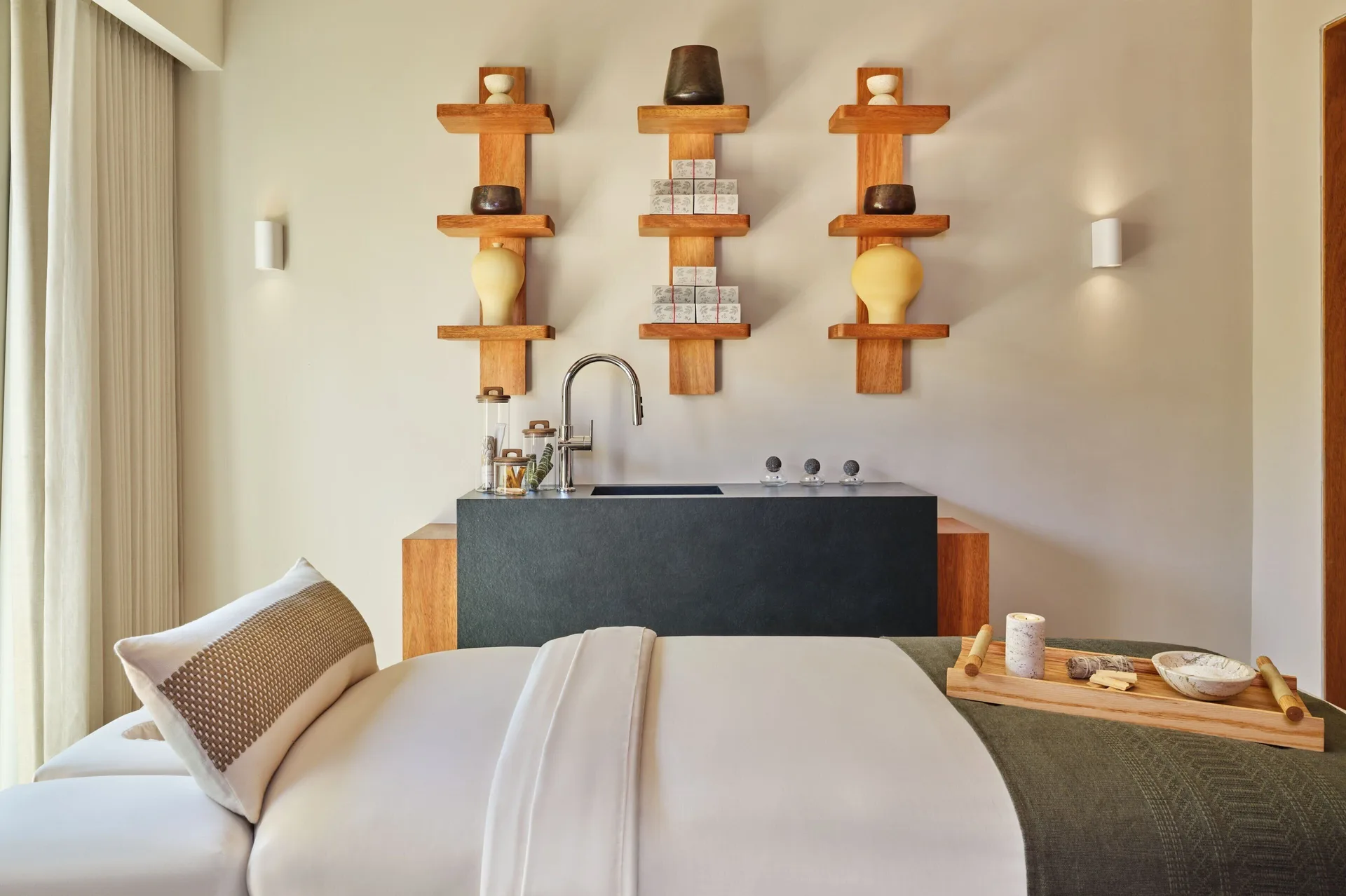 Spa treatment bed with wall shelves and sink at The St. Regis Punta Mita Resort.