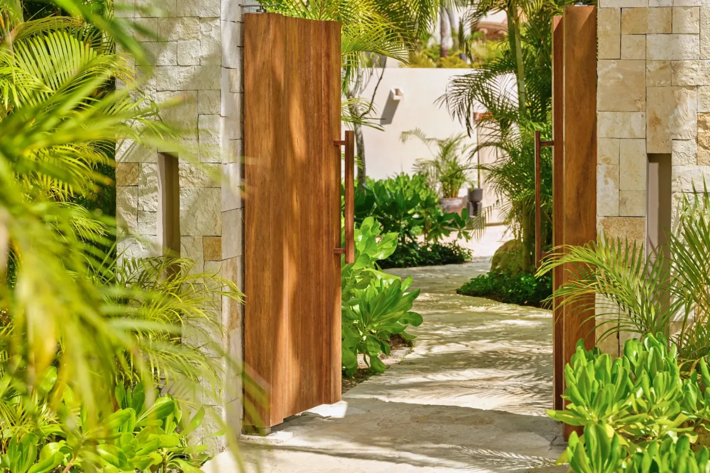 Open wooden garden gate along a lush path at The St. Regis Punta Mita Resort.