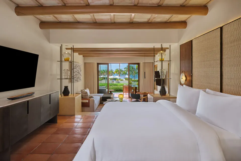Junior Suite Garden View king bed looking toward the terrace at The St. Regis Punta Mita Resort.