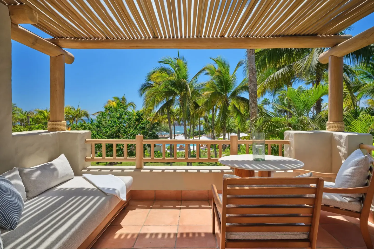 Ocean View room terrace with seating and palm-framed sea view at The St. Regis Punta Mita Resort.