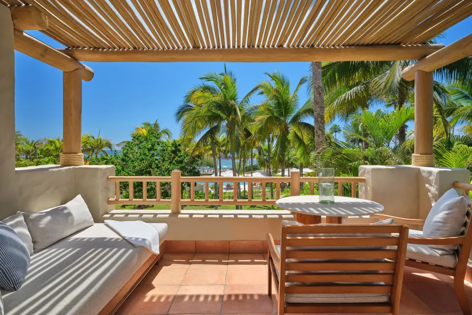 Ocean View room terrace with seating and palm-framed sea view at The St. Regis Punta Mita Resort.
