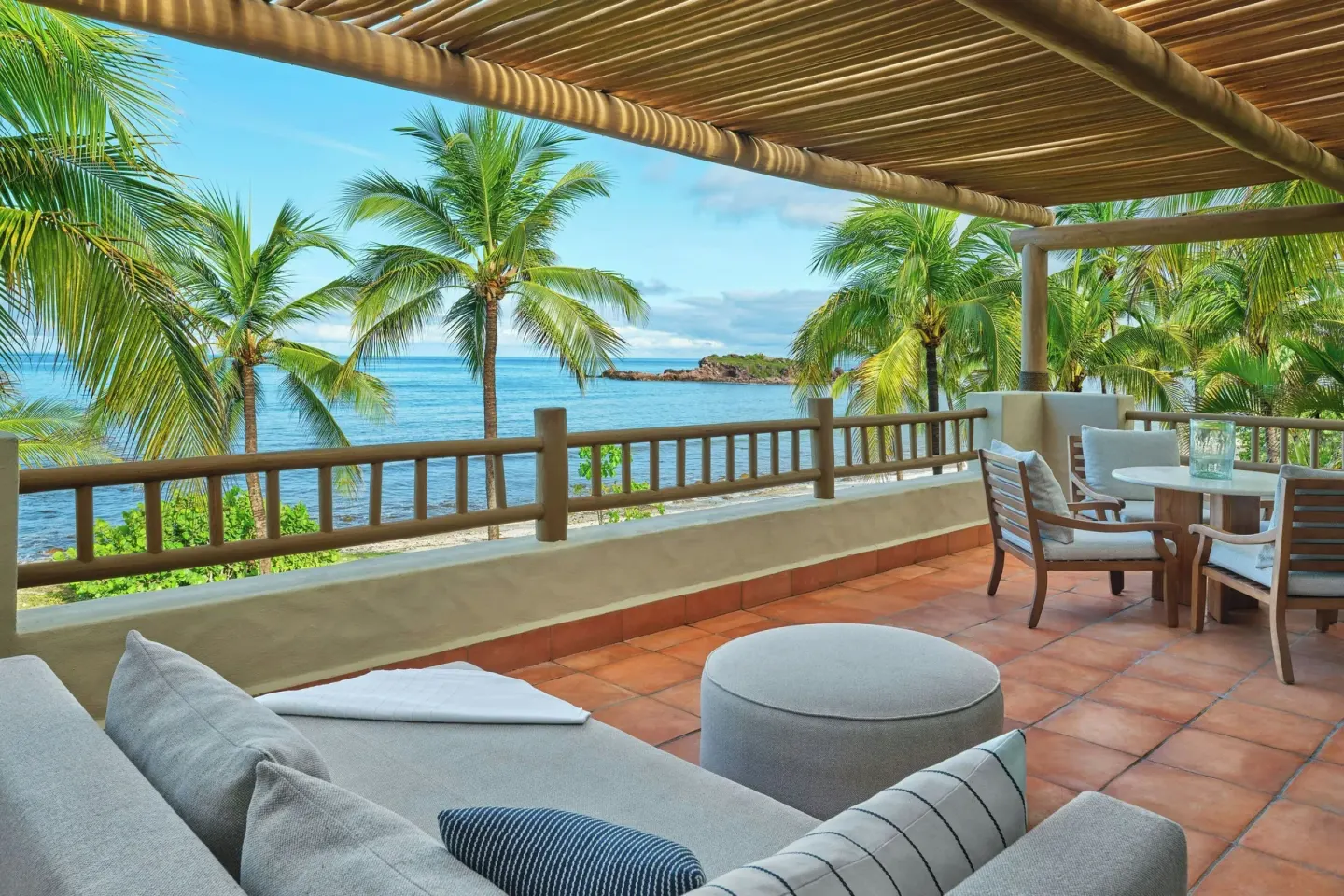 Beachfront suite terrace with ocean and palm views at The St. Regis Punta Mita Resort.