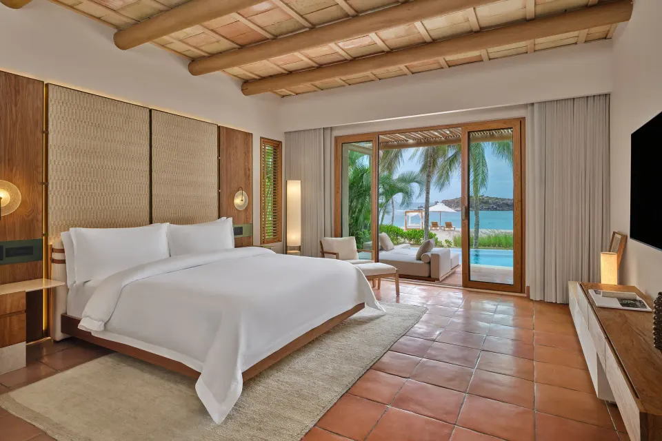 King bedroom in a beachfront villa at The St. Regis Punta Mita Resort opening to a terrace and pool.