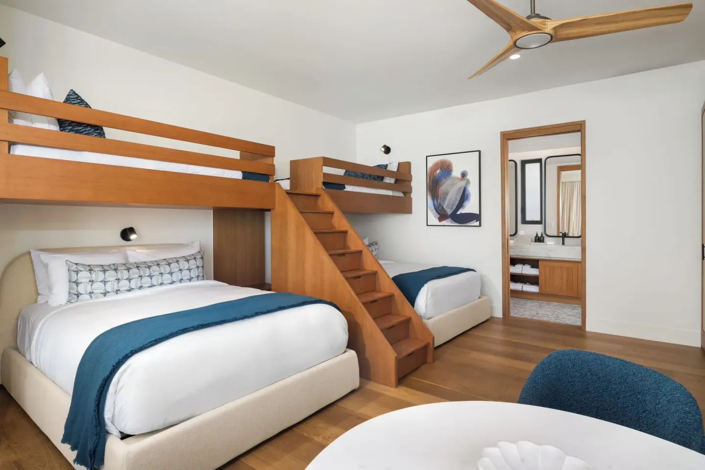 Bunk guest room with queen bed and blue accents at The Strand Turks and Caicos.