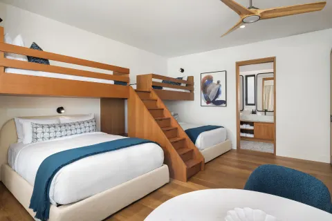 Bunk guest room with queen bed and blue accents at The Strand Turks and Caicos.