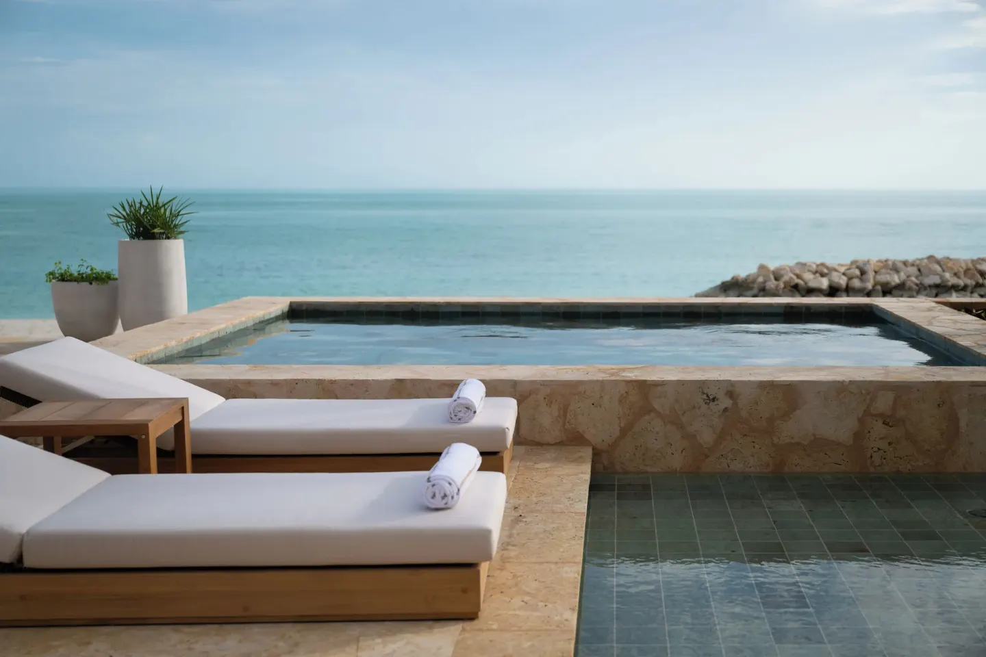 Oceanfront plunge pool with loungers and towels at The Strand Turks and Caicos.