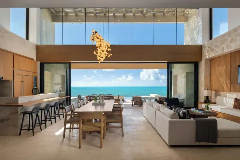 Open-plan oceanfront villa living and dining area at The Strand Turks and Caicos.