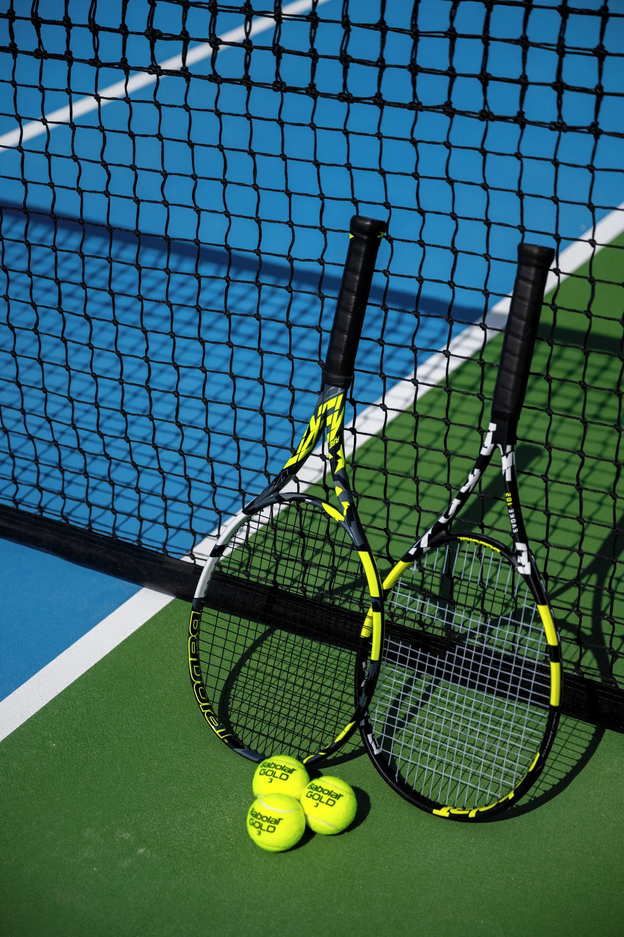 Tennis rackets and balls leaning on a court net at The Strand Turks and Caicos.