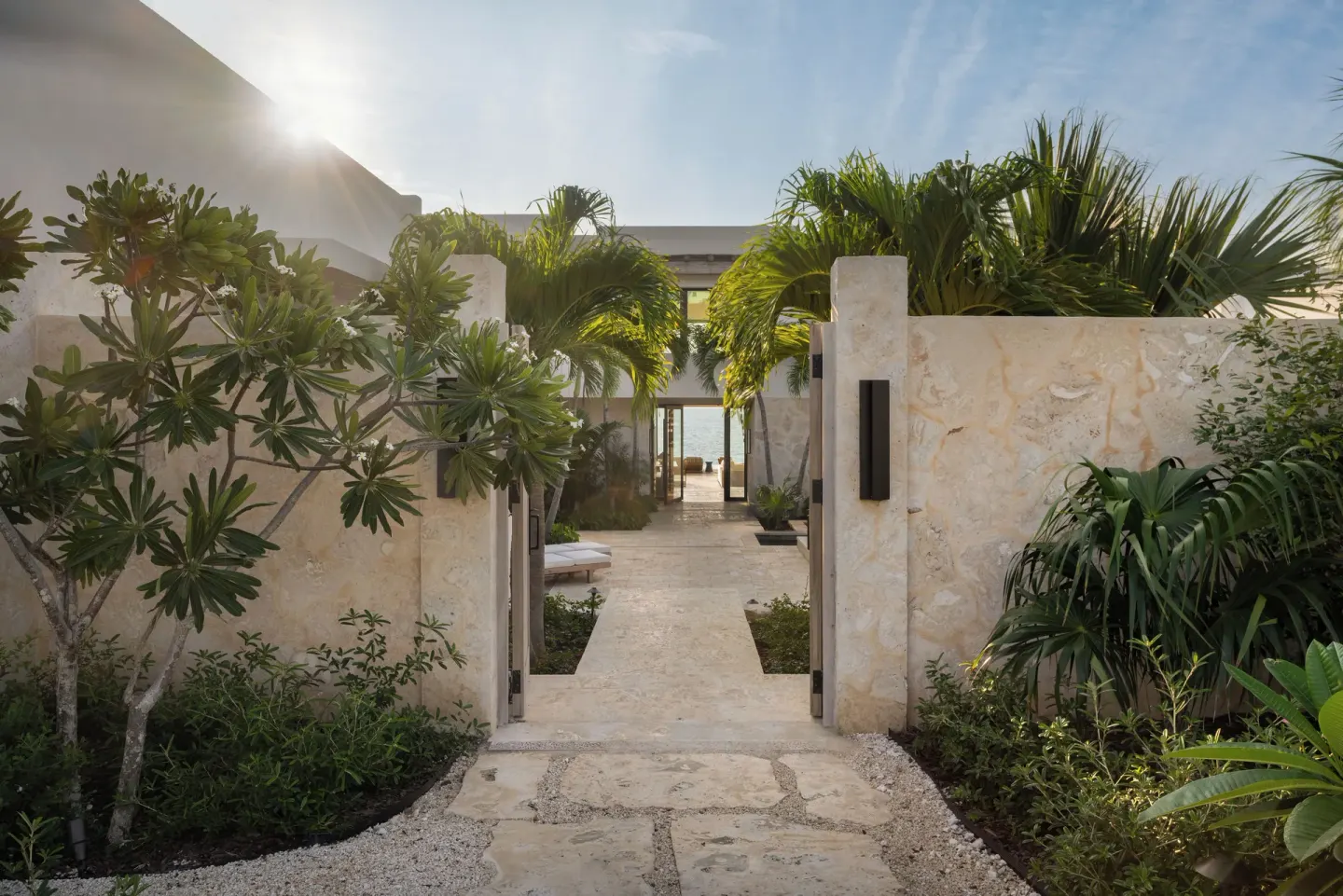 Tropical garden walkway between stone walls at The Strand Turks and Caicos.