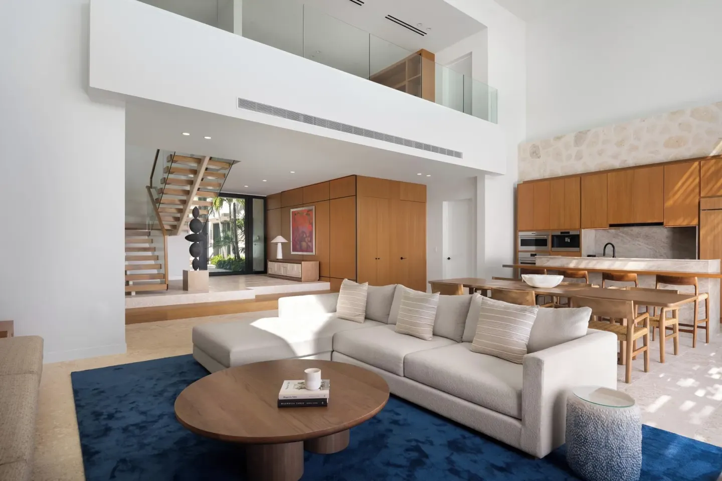 Two-level villa living room with kitchen and staircase at The Strand Turks and Caicos.