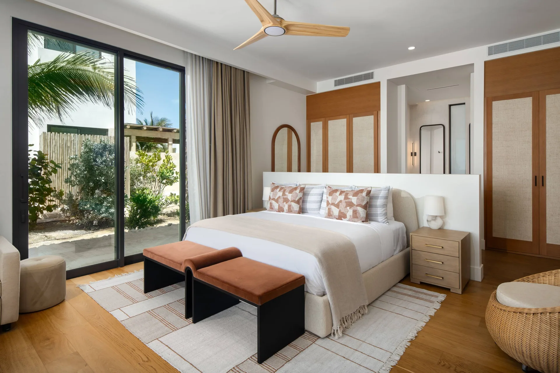 King bedroom with wood floors, garden doors, and wardrobe at The Strand Turks and Caicos.