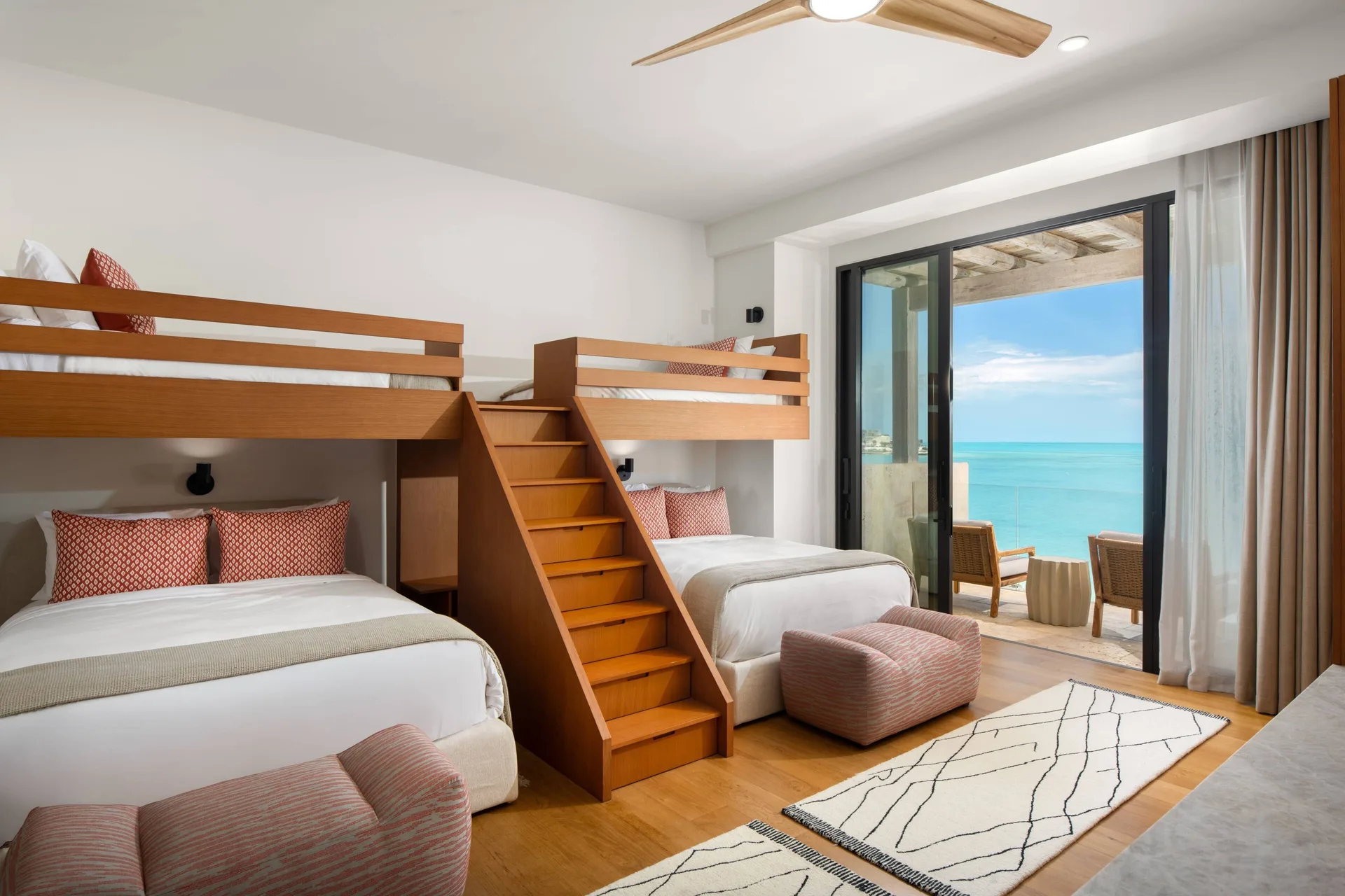 Bunk bedroom with four beds and an ocean-facing balcony at The Strand Turks and Caicos.