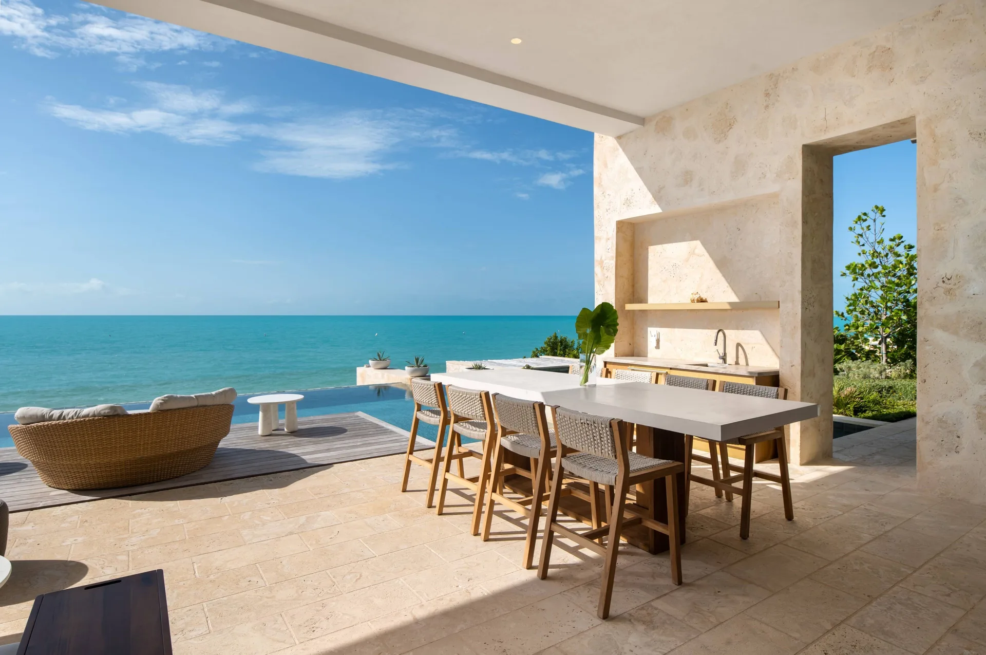 Covered patio dining area beside the ocean at The Strand Turks and Caicos.