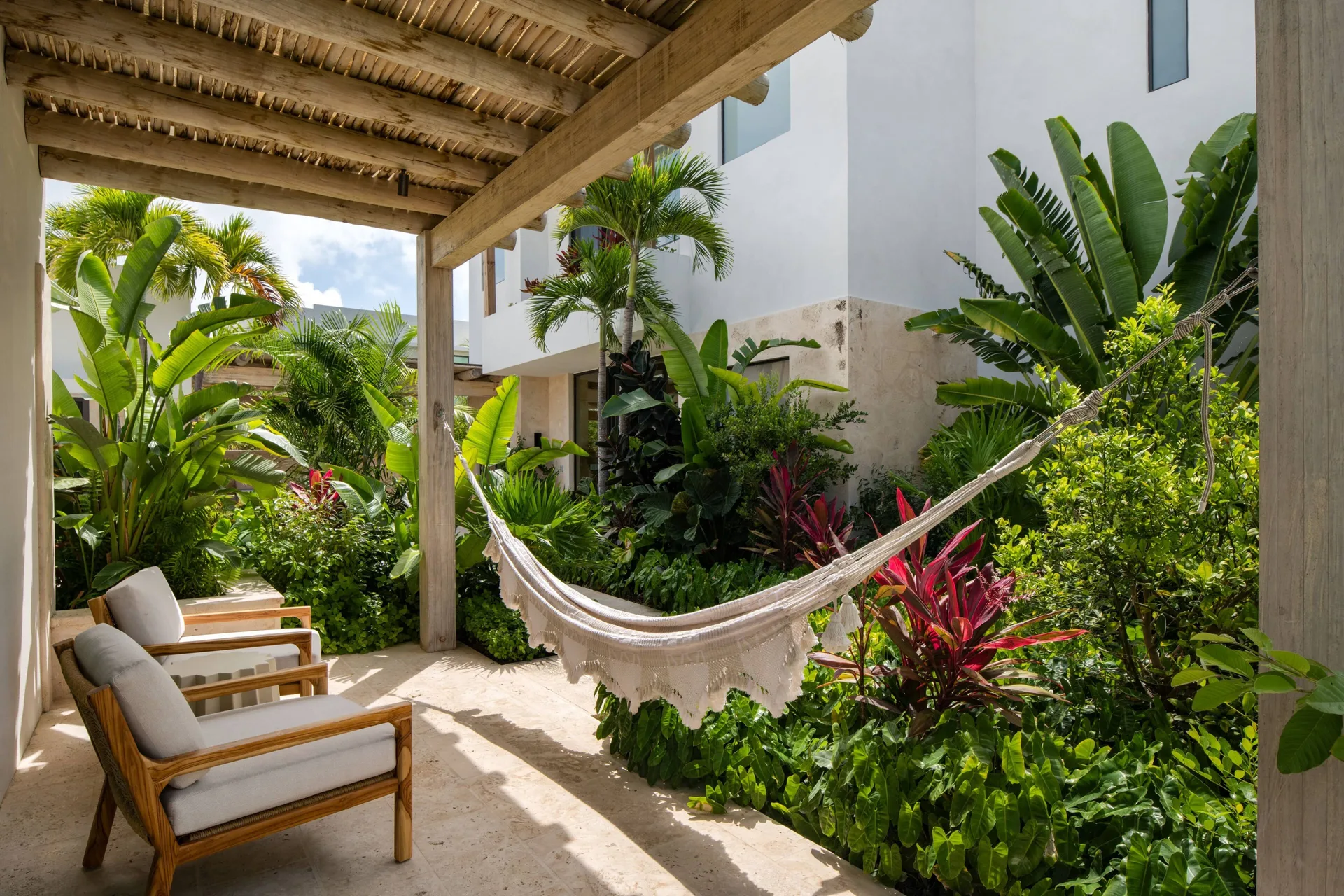 Garden patio with hammock and lounge chairs at The Strand Turks and Caicos.