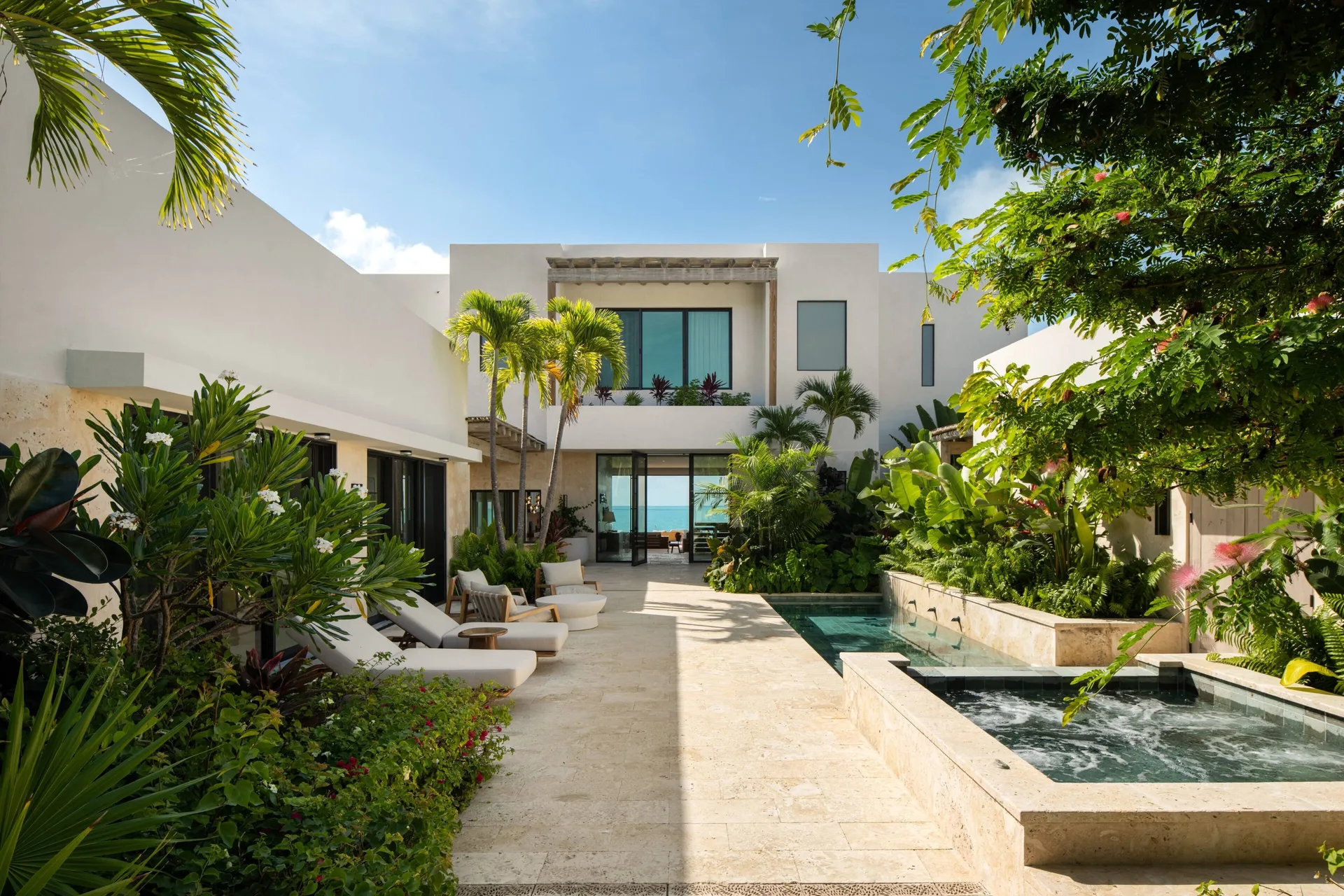 Grand Residence courtyard pool with loungers and palms at The Strand Turks and Caicos.