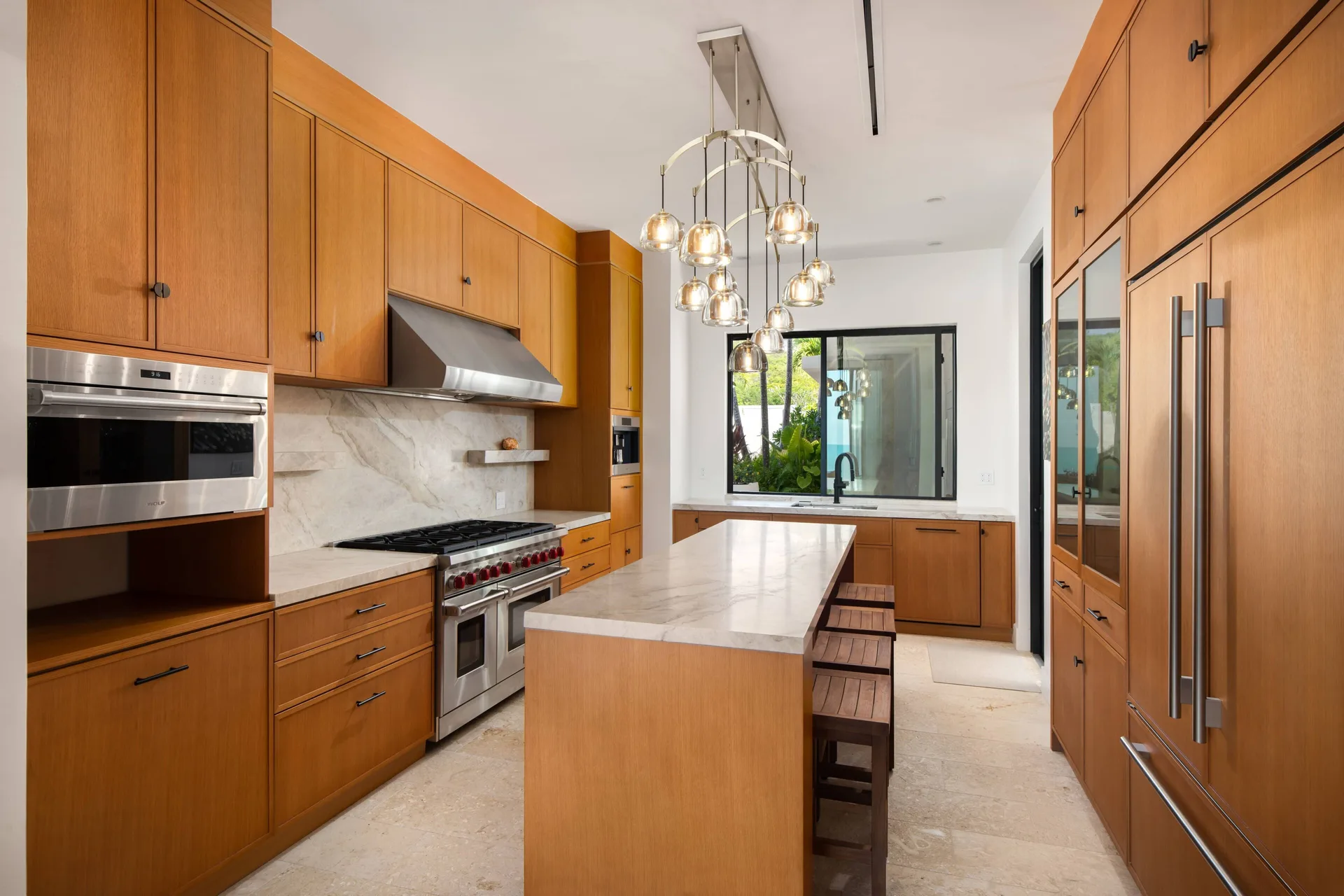 Wood-paneled kitchen with island and stainless appliances at The Strand Turks and Caicos.