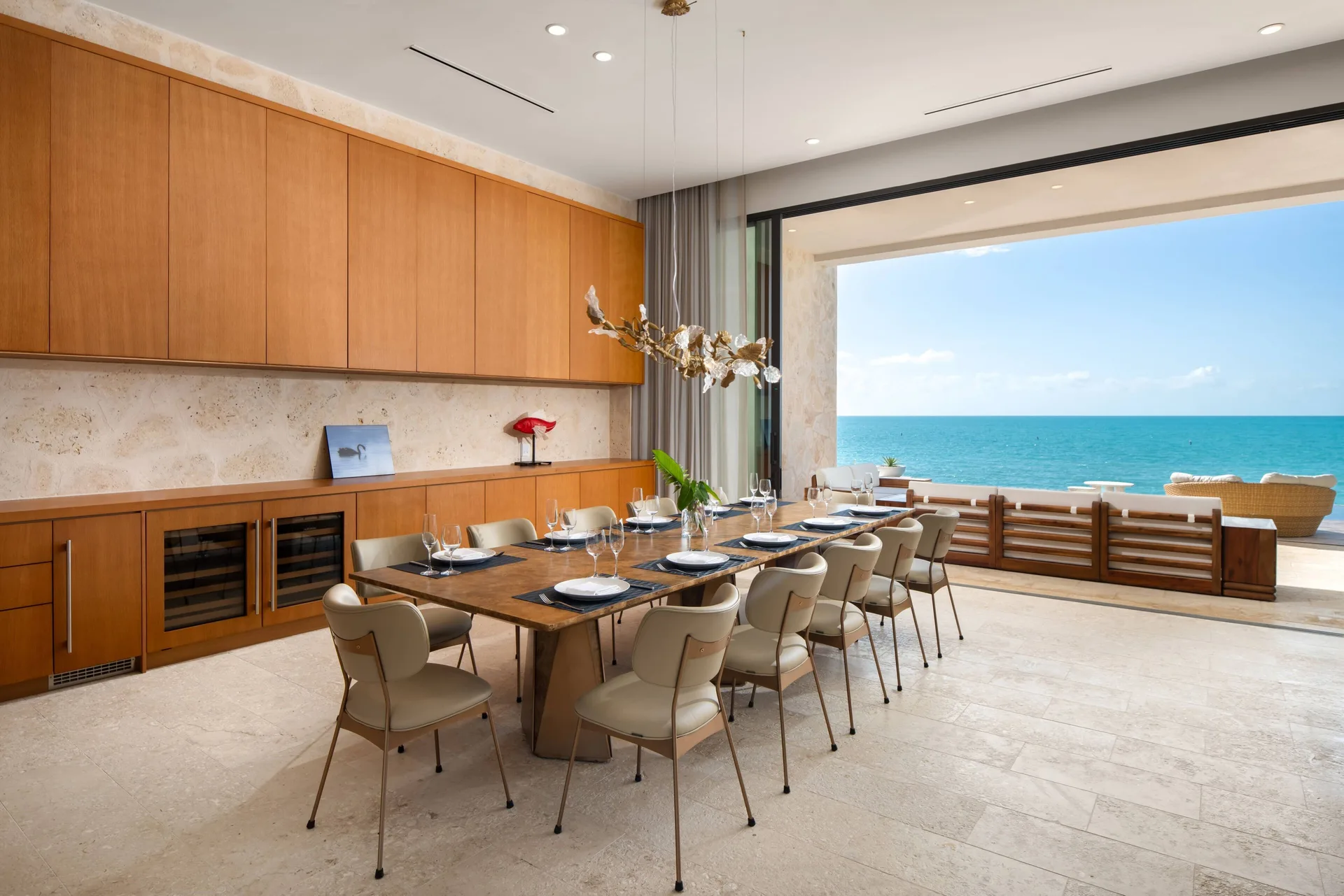 Oceanfront dining room with long table in the Grand Residence at The Strand Turks and Caicos.