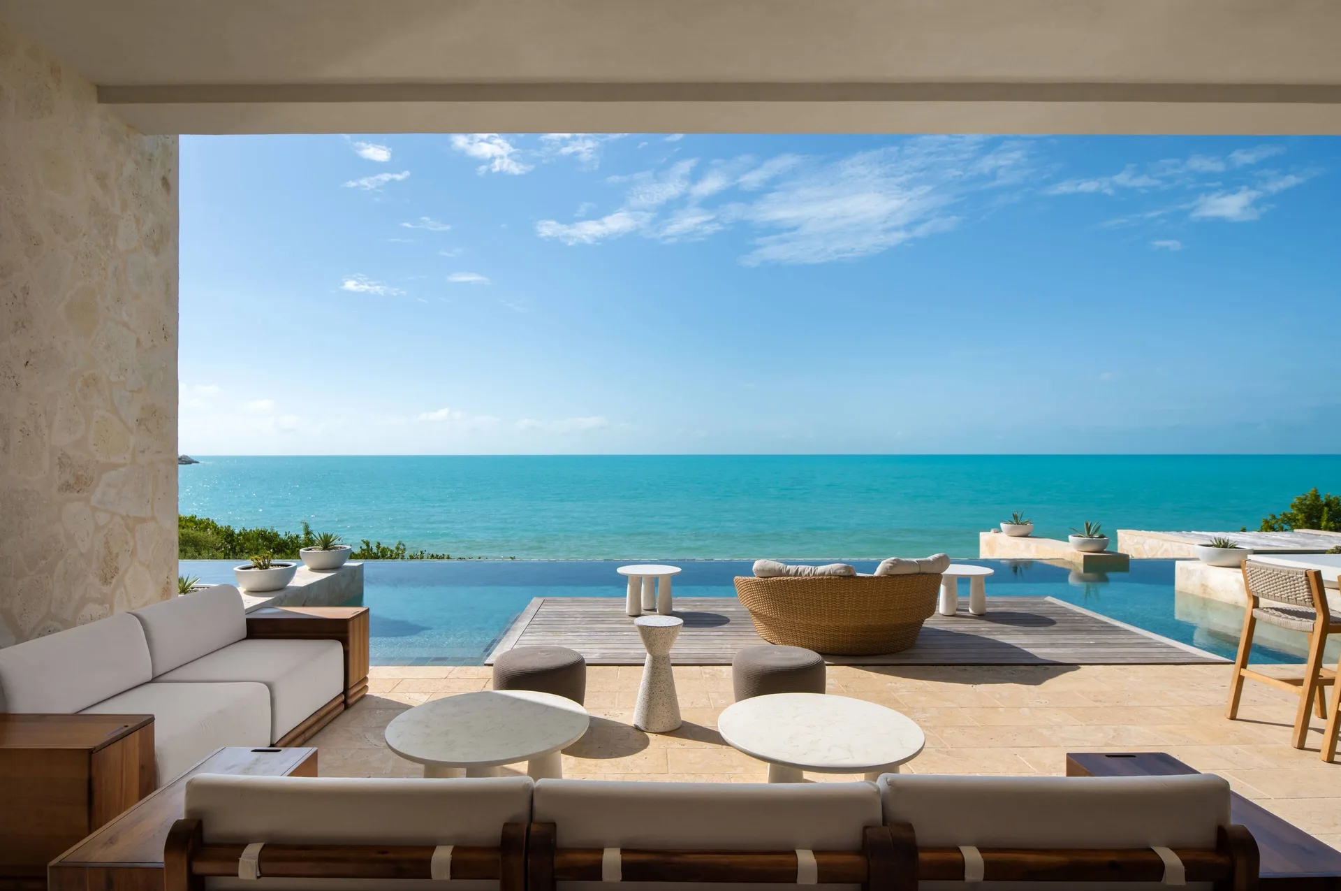 Covered terrace with infinity pool and ocean view at The Strand Turks and Caicos.