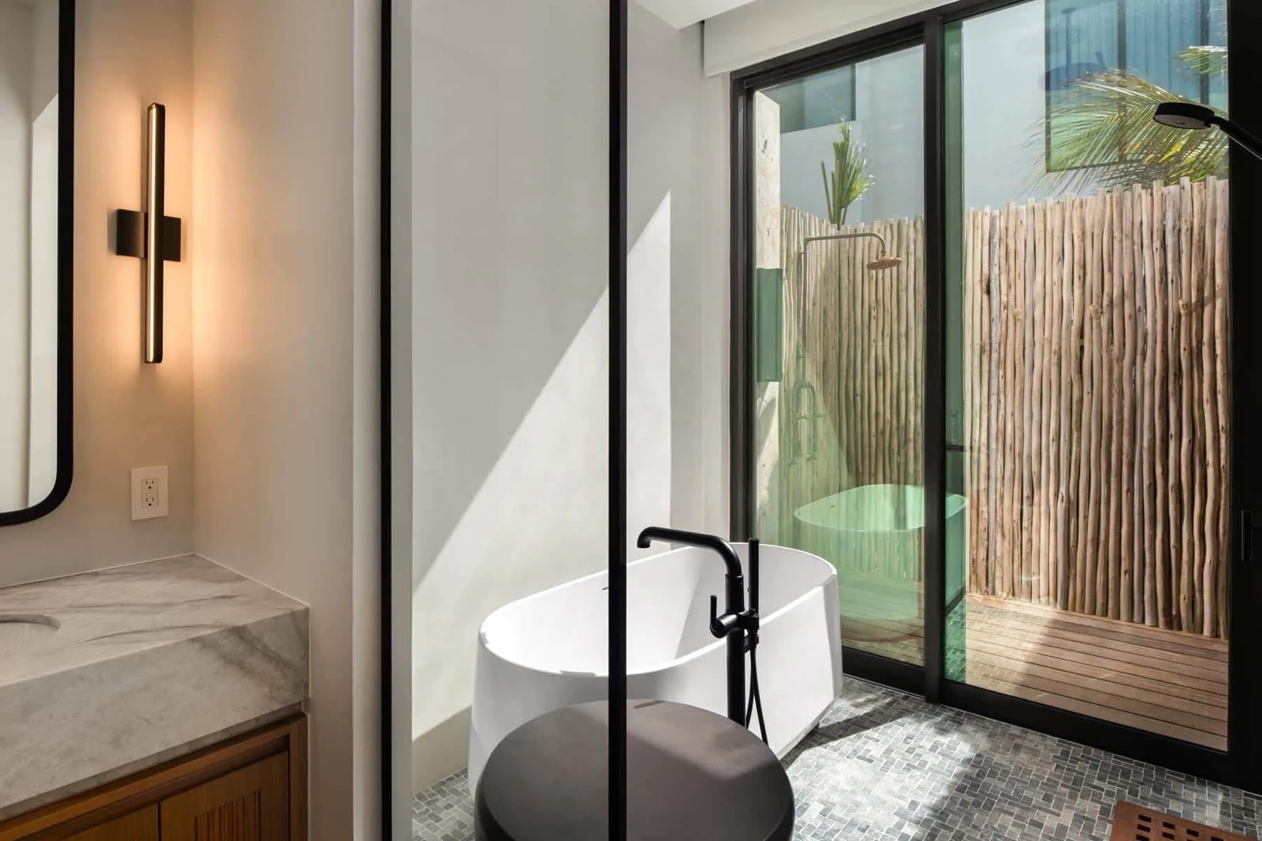 Bathroom soaking tub beside glass doors at The Strand Turks and Caicos.