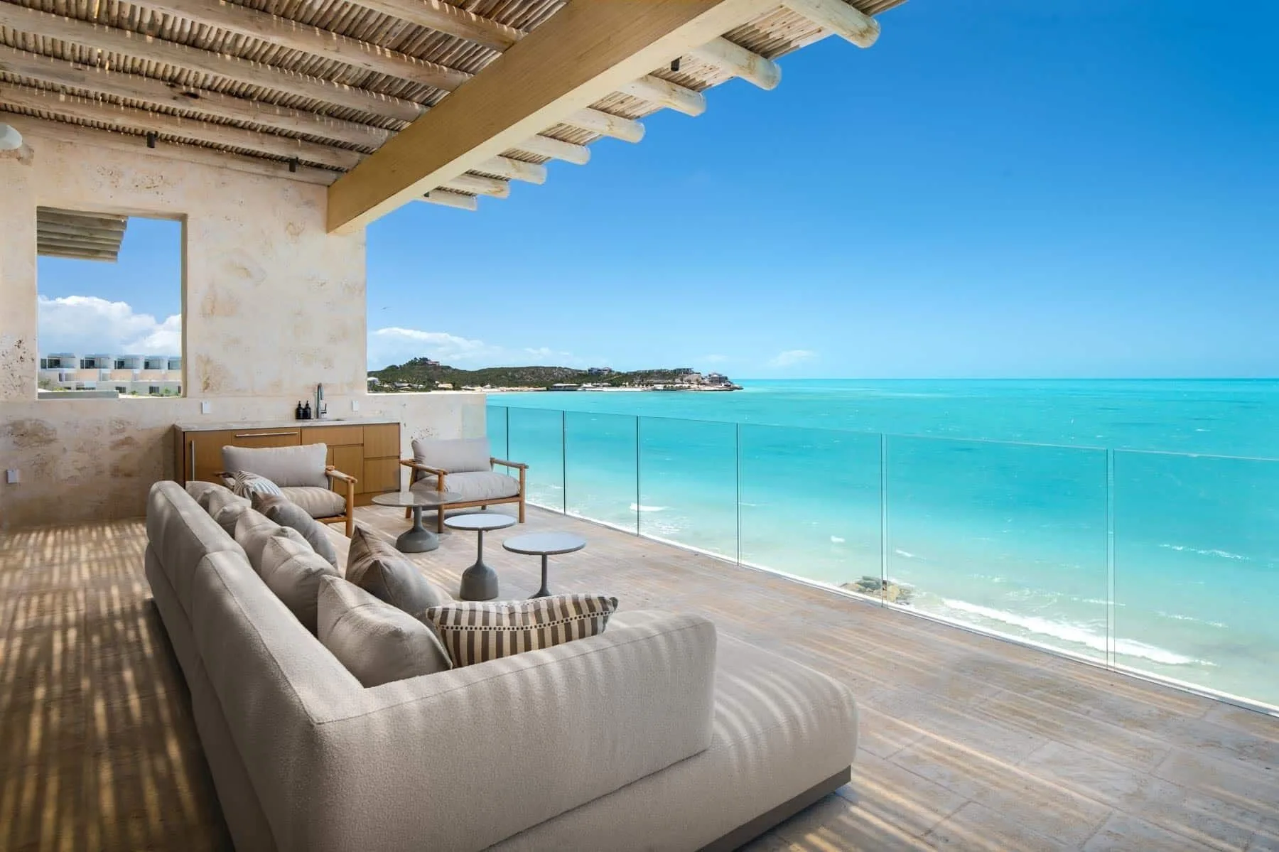 Covered ocean-view terrace with sofas at The Strand Turks and Caicos.