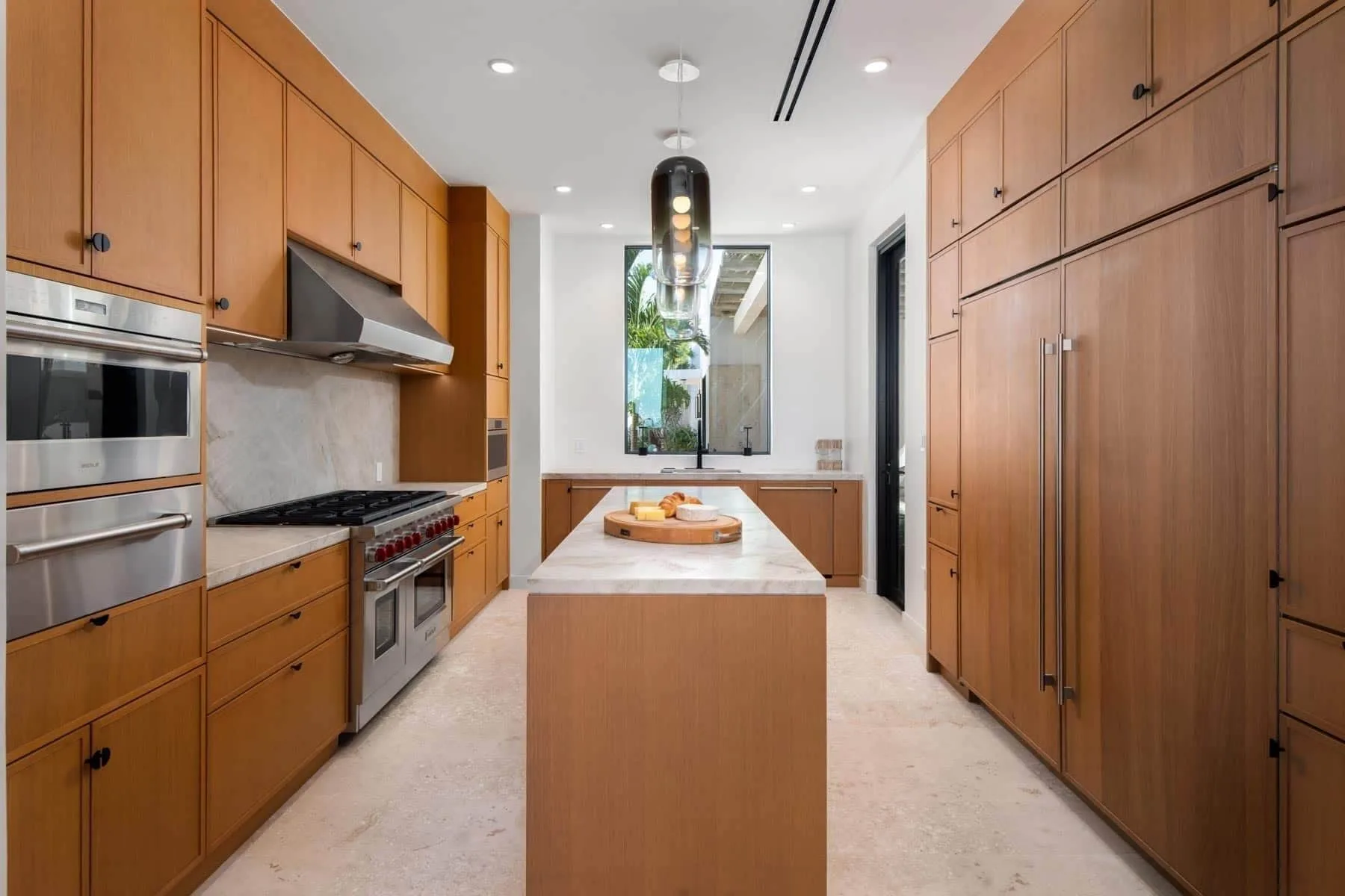 Wood-paneled kitchen with island in the Grand Residence at The Strand Turks and Caicos.