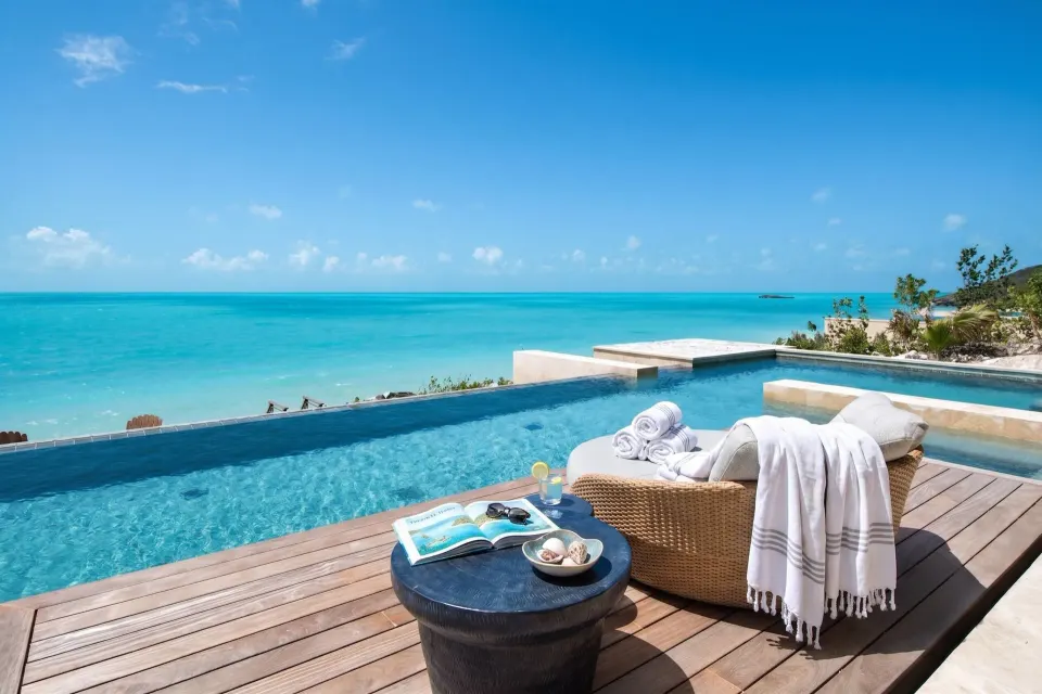 Oceanfront pool deck with lounge seating at the 7-Bedroom Grand Residence at The Strand Turks and Caicos.
